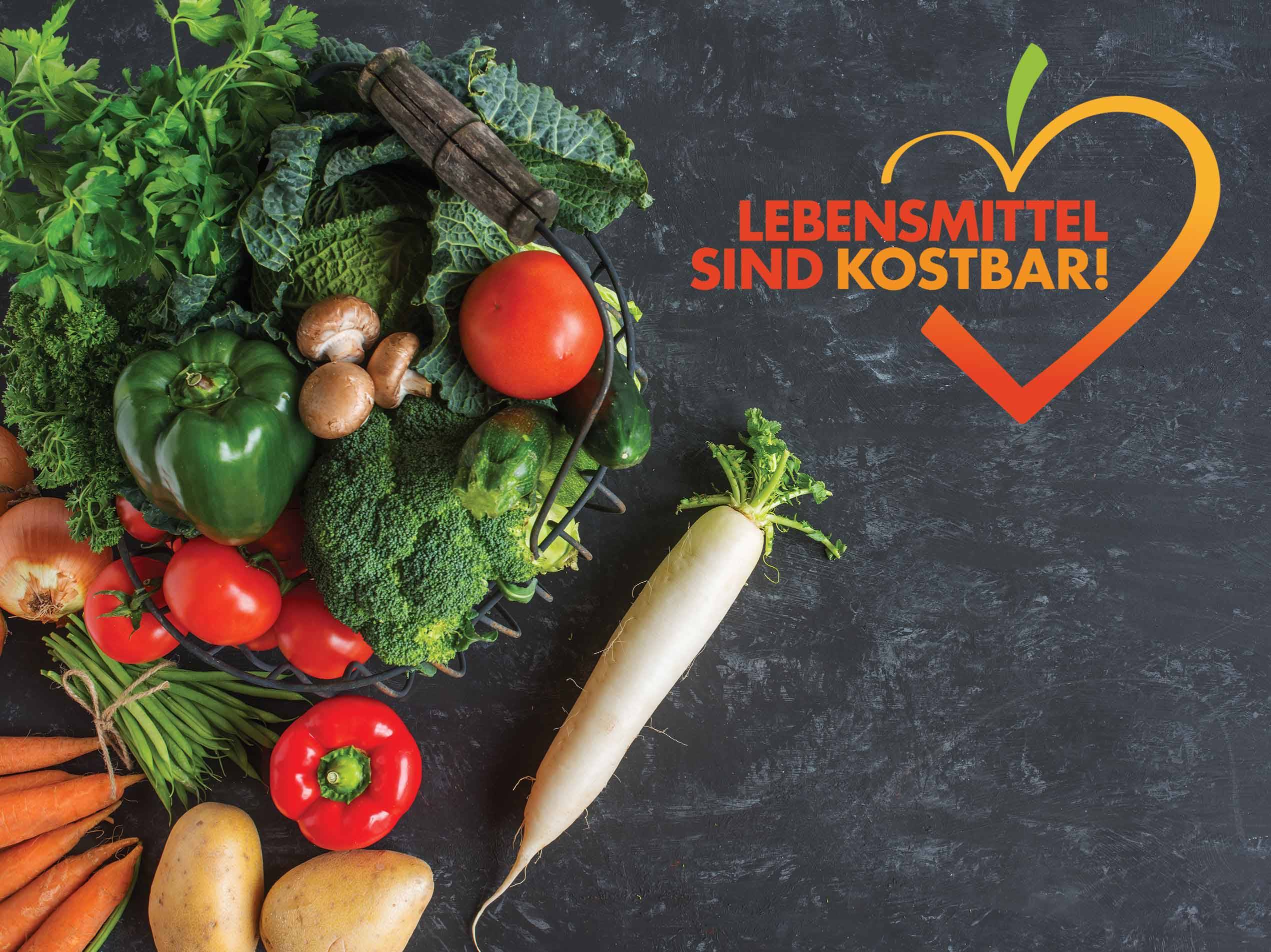 Obst und Gemüse auf schwarzem Hintergrund mit dem Zusatz "Lebensmittel sind kostbar"